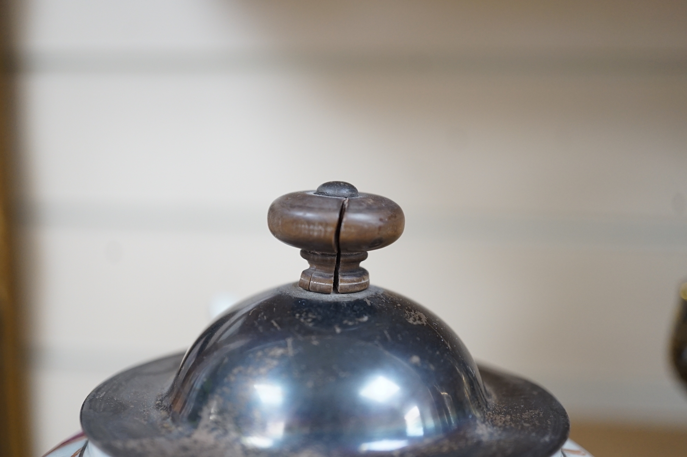 An 18th century Chinese export famille rose teapot with later silver spout and cover, on hardwood stand